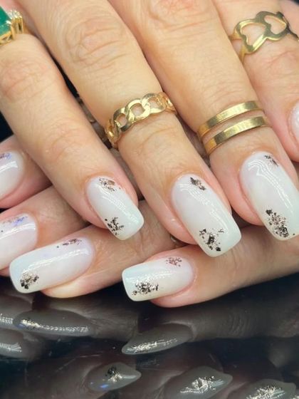 A side view of the elegant white and silver foil manicure.