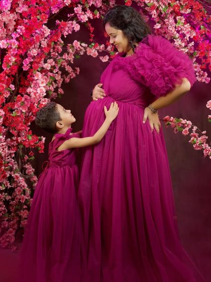 A touching moment between a mother and her daughter during their maternity shoot. Our rental gowns help make these special photoshoots even more memorable.