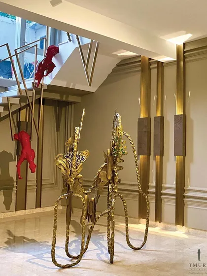 We believe art should be integrated, not just placed. In this entryway, we installed bold, sculptural art pieces that interact with the architecture, including custom red panthers that climb the bespoke staircase, creating an unforgettable first impression.