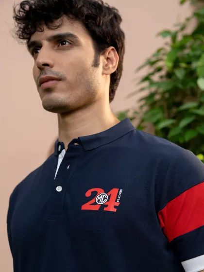 A close-up of a model wearing an MG Motor branded polo shirt. The shot is tightly framed to emphasize the logo and fabric texture, ideal for commercial and catalogue use.