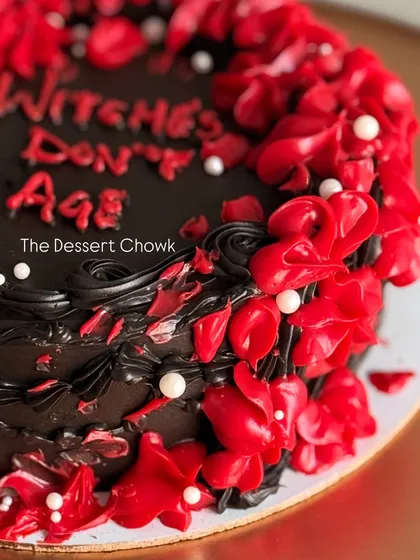 A close-up of the fiery red buttercream details on the "Witches Don't Age" cake.