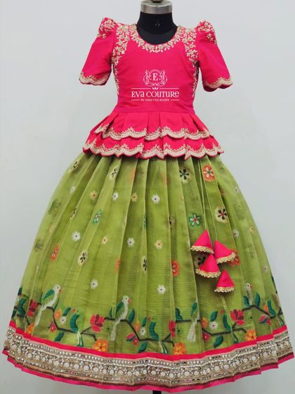 A beautiful organza lehenga with an embroidered bird print. The pink peplum blouse has scalloped edges and delicate embroidery.