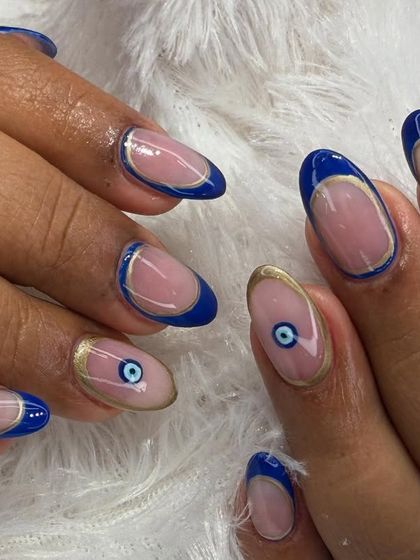 Another take on the popular evil eye trend. This design combines the symbol with a classic blue French tip and delicate gold accents for a chic and meaningful look.