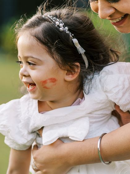 A little girl with a lipstick kiss on her cheek. A funny and sweet moment from a family session.