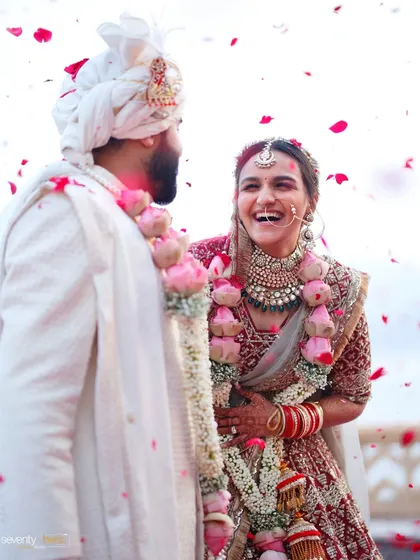 A shower of rose petals and a burst of laughter. A candid, joyful moment from the varmala ceremony in Udaipur.