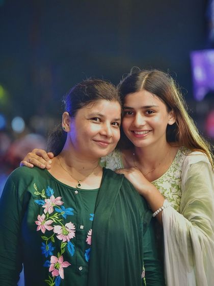 A classic mother-daughter portrait. Their warm smiles and the beautiful lighting make this a timeless and cherished memory captured at night.