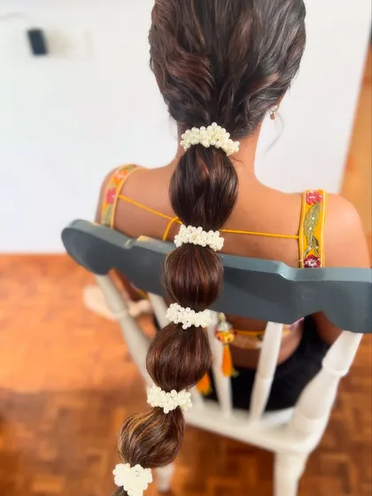 A close-up of the bubble braid, showing the neat sections wrapped with pearl accessories. This is a fun and stylish option for any festive occasion.