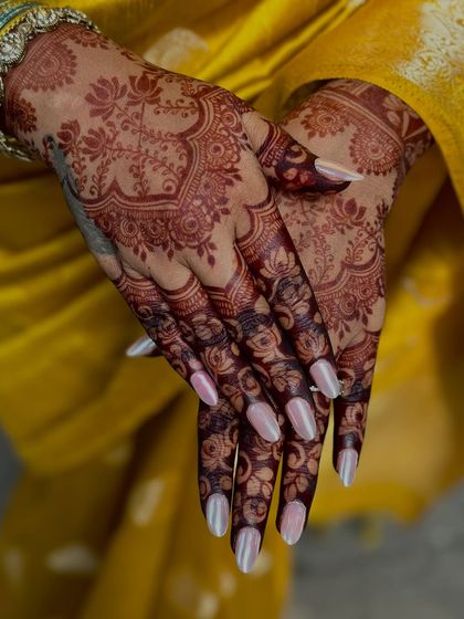 The back of the hands, where the dark stain makes the floral patterns pop.