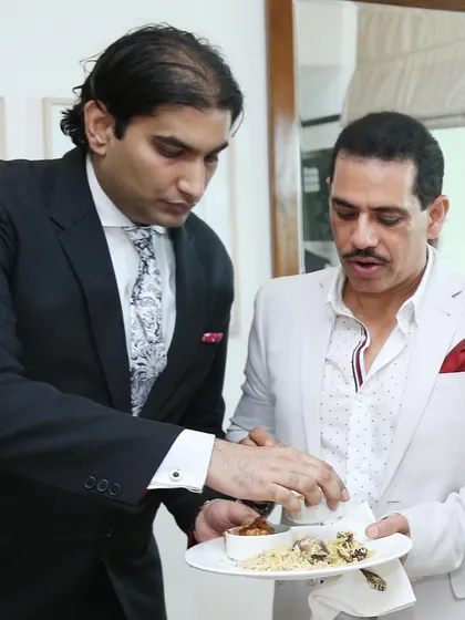Assisting Mr. Robert Vadra with his plate. This hands-on service is part of the personal touch that defines our brand.