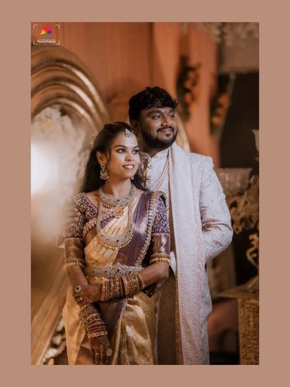 A candid and happy reception portrait. The couple's genuine smiles and the grand decor in the background perfectly capture the celebratory atmosphere.
