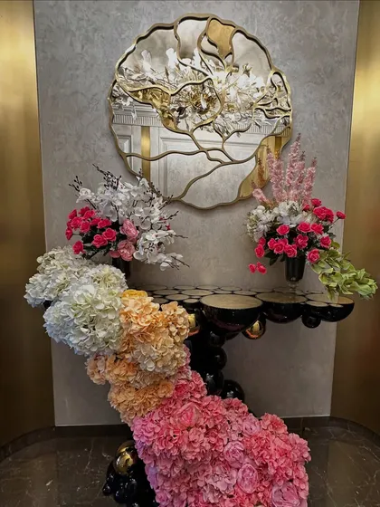 A stunning cascading floral arrangement flowing down from a console table. We used an ombre effect with flowers transitioning from white and peach to pink and deep magenta, creating a waterfall of color.