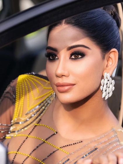 A close-up of a glamorous cocktail look. The makeup features a dramatic, black smokey eye and a nude lip, perfect for a night out.