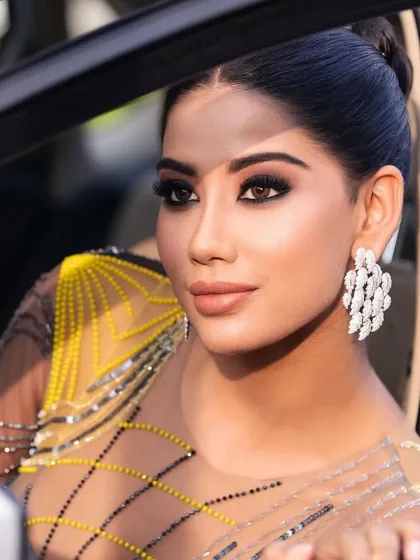 A close-up of a glamorous cocktail look. The makeup features a dramatic, black smokey eye and a nude lip, perfect for a night out.