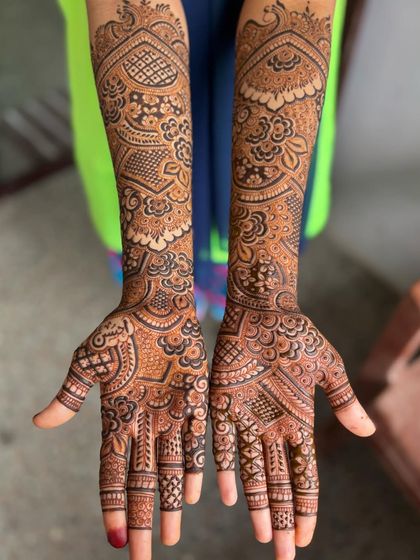 An engagement mehendi with a mix of peacocks, florals, and traditional Indian motifs. The design is different on each hand for a unique, customized feel.