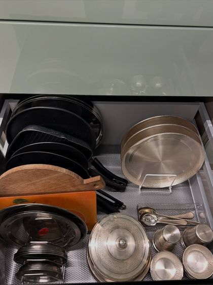 This drawer holds steel lids, chopping boards, and other flat items. Storing them vertically is the most efficient way to use the space.