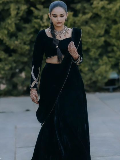 A full-length view of the black velvet lehenga saree. The simplicity of the design is what makes it so powerful and elegant.