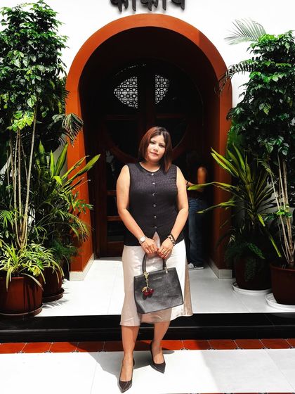 A sophisticated lunch look. I paired a sleeveless dark vest with a light-colored skirt and classic black pumps for a polished and professional outfit.