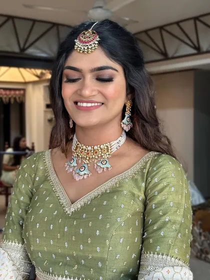 Soft smokey eyes with a hint of glitter. A beautiful look in a green and white lehenga.