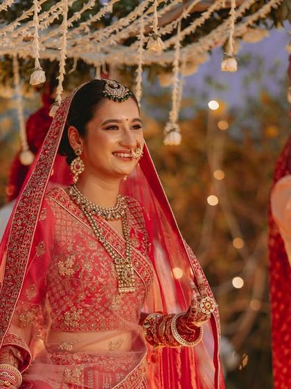 The bride's radiant smile as she walks towards the mandap, her happiness lighting up the frame.