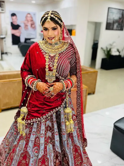 A full-length view of the bride, showcasing her unique grey and red lehenga. The entire look is grand and majestic, perfect for a royal-themed wedding.