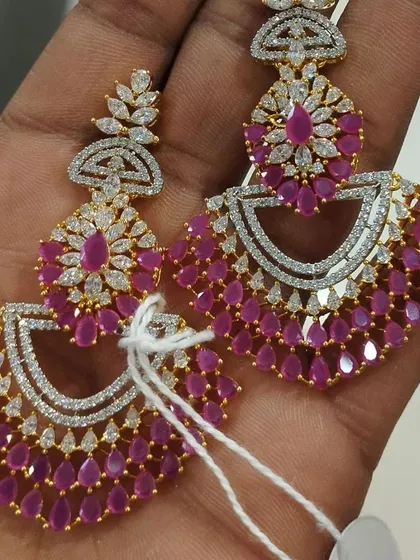 For those who love sparkle, these American Diamond chandbalis are a perfect choice. The fine cutting of the stones gives them a brilliant shine, and the ruby-colored drops add a touch of vibrant color, making them ideal for evening parties.