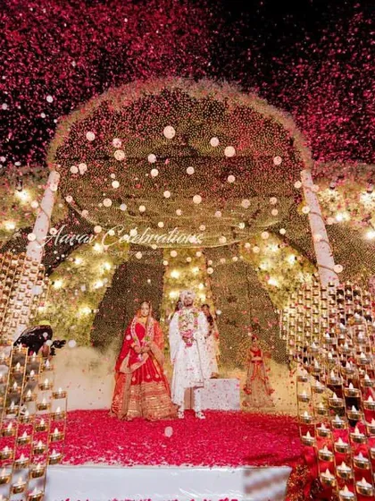 A grand Jaimala with a 'Diya' theme. The couple stands on a stage surrounded by hundreds of lit diyas, creating a warm, glittering, and spiritually resonant setting for their union.