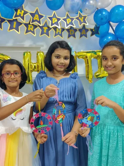 The birthday girl and her friends showing off the beautiful Diwali-themed hangings they made during her party.