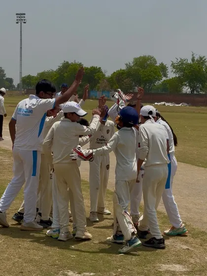 A team huddle to celebrate a wicket. Unity is our strength.