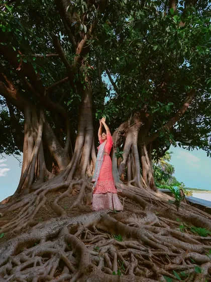 A creative pose under the sprawling branches of a banyan tree. This shot captures a sense of grace and connection with the natural world.
