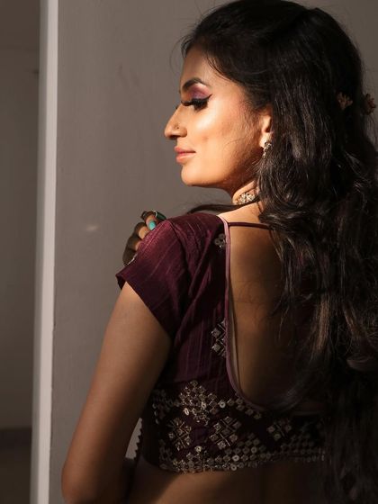 A beautiful, unedited shot of a client ready for a family function. The purple eye makeup is soft and blended, and her skin looks naturally radiant in the sunlight.