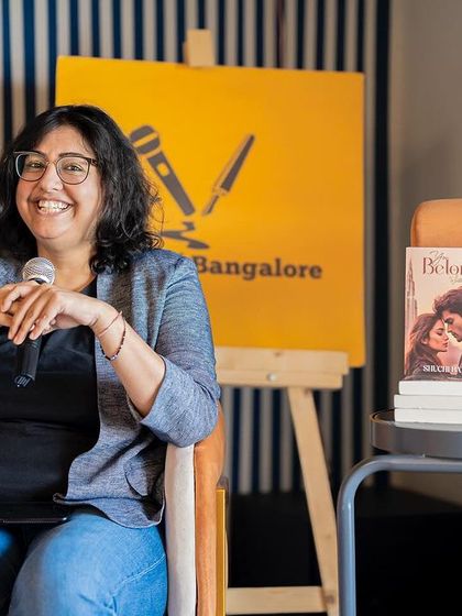 Author Shuchi Batra smiling warmly at the audience, comfortable and confident on the stage we've set for her.