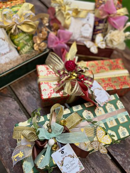 A collection of wedding hampers and gifts showcasing a variety of modern Indian wrapping styles. From rich brocade patterns to delicate floral prints, each gift is a unique piece of art.