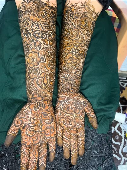 A complete view of a full bridal mehendi set, covering both hands and arms up to the elbows in a stunning, cohesive design.