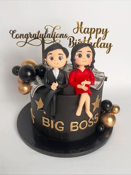 Double the reason to celebrate. This "Big Boss" cake marks a promotion and a birthday, featuring handcrafted figurines of the couple sitting on a cake overflowing with edible money.