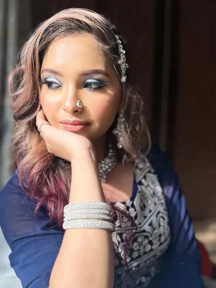 A thoughtful pose by the window, where natural light illuminates the metallic eyeshadow and highlights the flawless complexion of this Walima bride look.