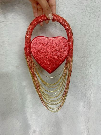 Introducing my mini heart fringe bag, a trendy and glamorous piece. It features a red heart-shaped compartment with cascading red and gold fringe, perfect for making a bold style statement.