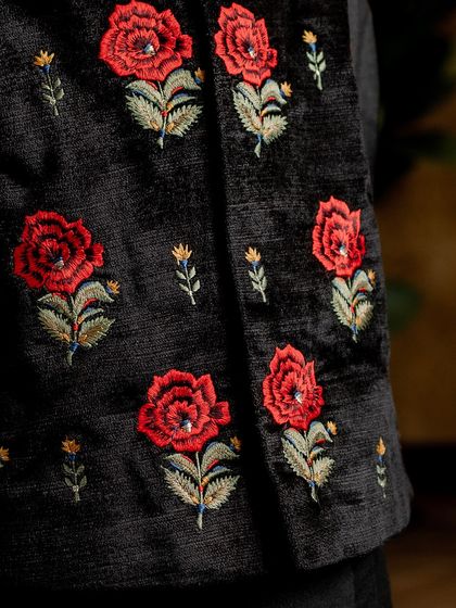 Another detailed shot of the red rose embroidery. This angle shows the dimension and artistry of the handwork, a signature of our couture collection.