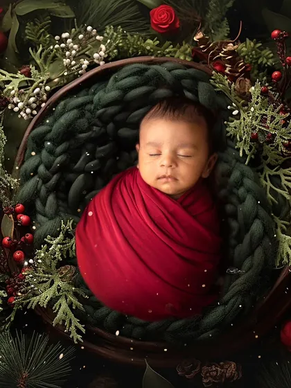 A classic Christmas portrait with the baby nestled in a basket of festive greenery. The rich colors and soft lighting create a timeless holiday feel.