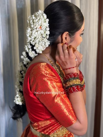 A side view of the jasmine braid, showing how it perfectly complements the bride's red silk saree and traditional jewellery.