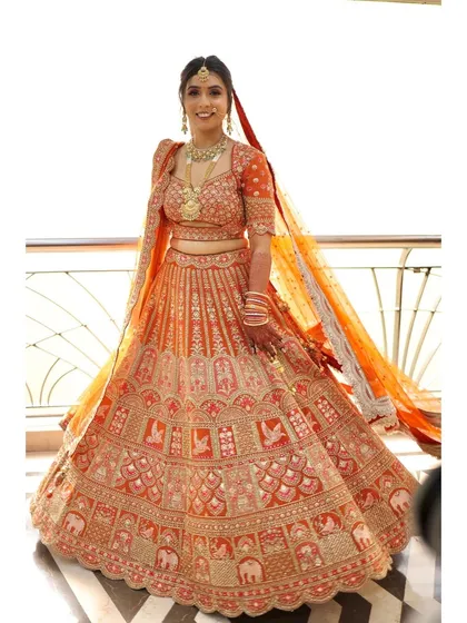 The full bridal look. The orange lehenga is a stunning choice, and the makeup was designed to complement its warmth and richness.