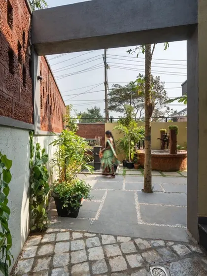 We believe in blending modern design with local traditions. This courtyard in 'Jodi Mane' integrates green pockets with vernacular elements like a Tulsi katte and a well, grounding the contemporary home in its cultural context.