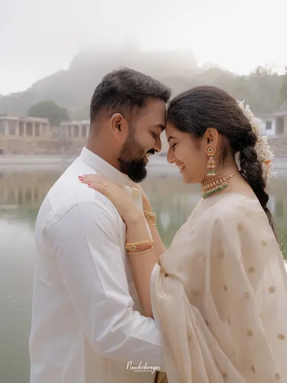 A tender moment as a couple touches foreheads by the sacred temple pond at Melukote, their reflections soft in the water below. This is the kind of intimate, serene portrait I love to create.