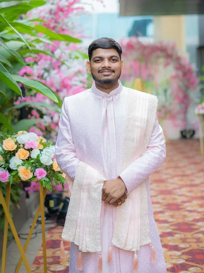 A classic portrait of the groom on his Haldi day, smiling in his elegant pastel sherwani.