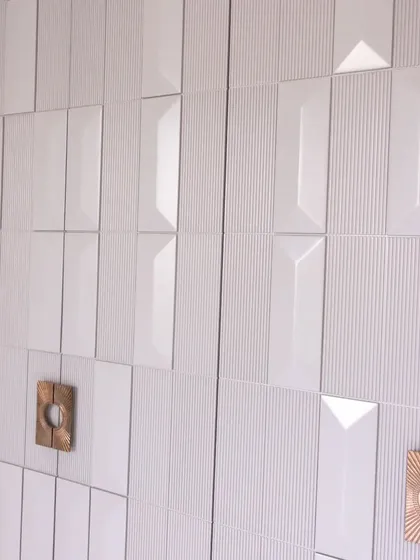 The interplay of light and shadow on the 3D-paneled shutters creates a dynamic effect, making this wardrobe a focal point in any room.