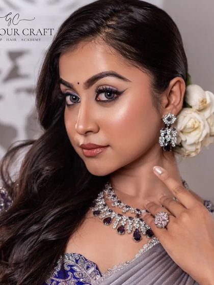 The delicate white roses in her hair add a touch of romance to this modern silver saree look. It's a perfect example of refined elegance.