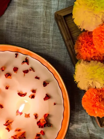 An overhead shot of our rose petal candle bowl, styled with marigold garlands for a truly festive feel. A beautiful way to illuminate the season of giving.