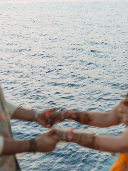 An artistic, motion-blur shot of a couple holding hands against the backdrop of the ocean.