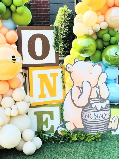 Another view of the 'ONE' blocks and Pooh character, surrounded by a cheerful mix of balloons.