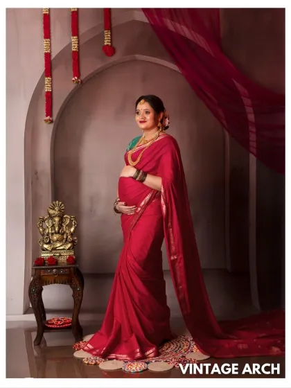 A beautiful solo portrait in a red saree, standing gracefully in our vintage arch setup.