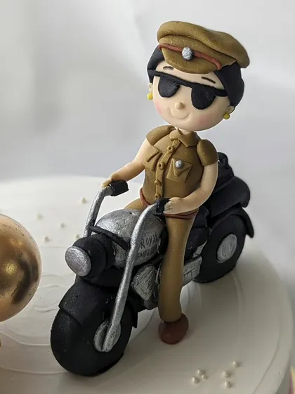 A close-up of the handcrafted figurine from the police inspector cake. I pay close attention to details like the uniform, sunglasses, and motorcycle to create a realistic and personalized cake topper.